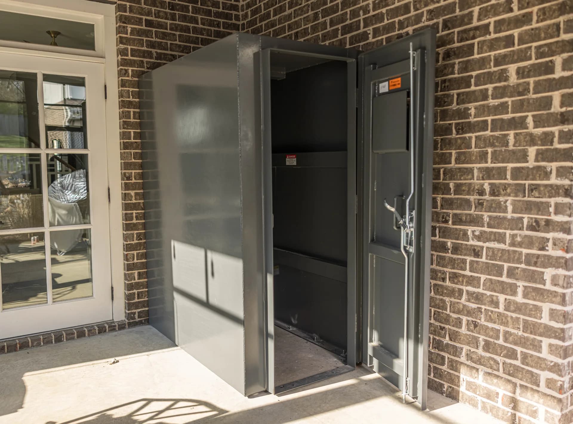 Reinforced steel storm shelter door open to interior